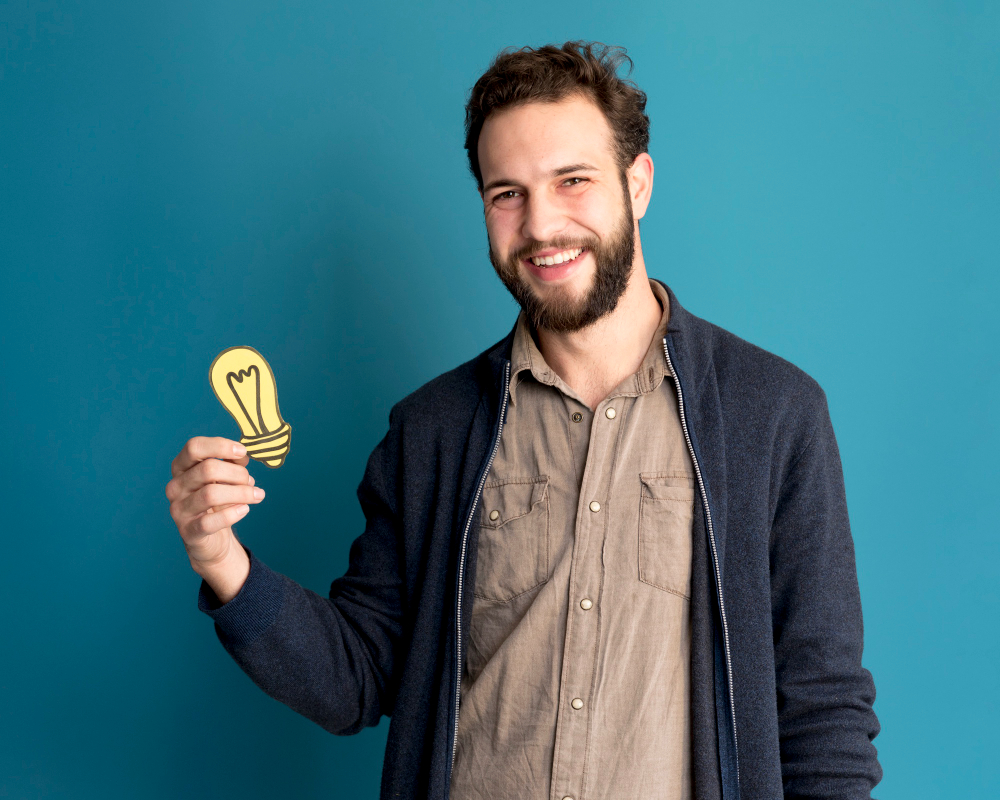 Smiling man holding a glowing light bulb