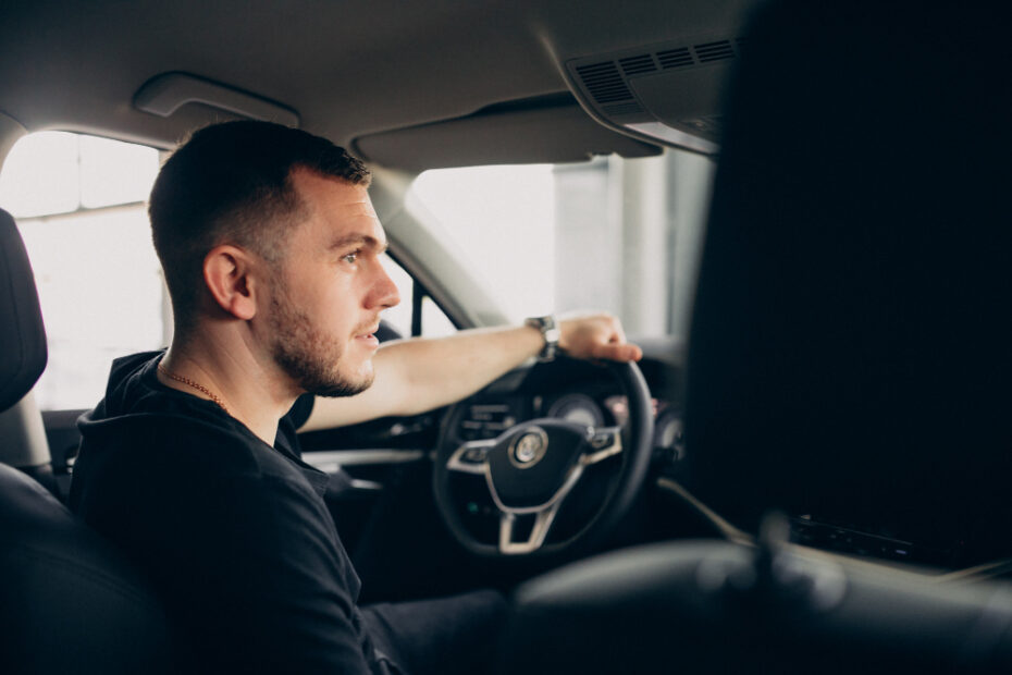 Man in black clothes driving his car posing side profile