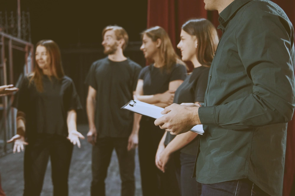 Group of actors talking to each other in a theatre