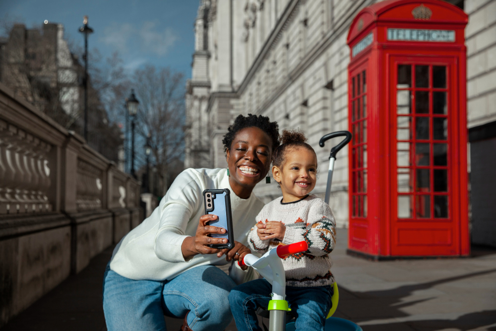 A mother and daughter standing by a classic red British phone box, symbolising family unity and the UK Family Visa route.
